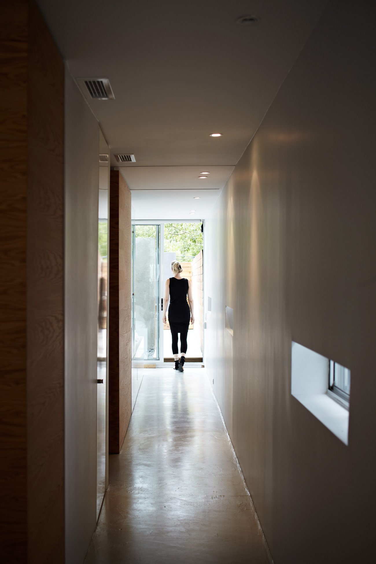 transforming home - A hallway off the kitchen leads past a hidden coat closet, laundry area and guest washroom to the private quarters and patio.