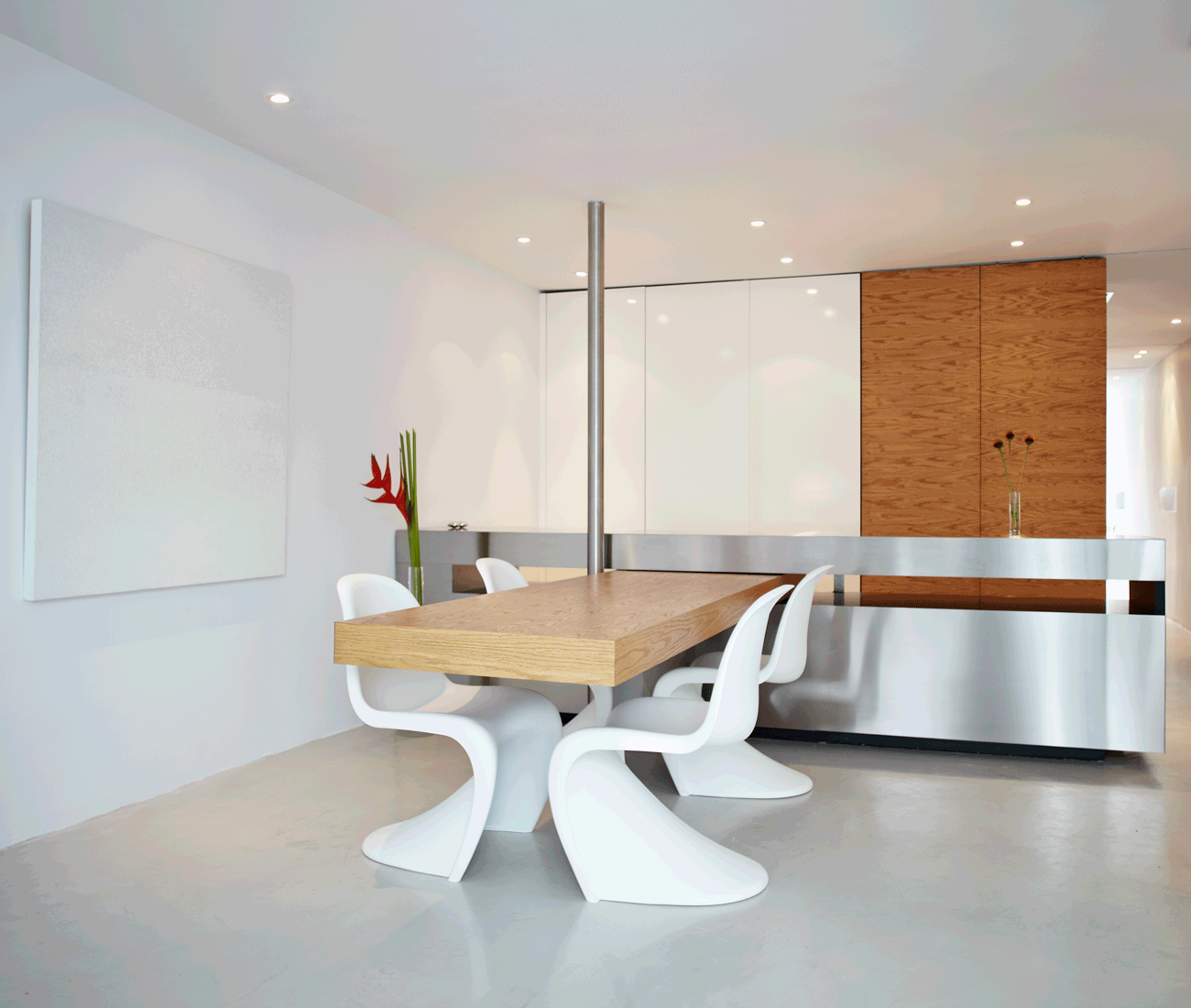 transforming home - Oak dining table swings out from the stainless steel kitchen countertop.
