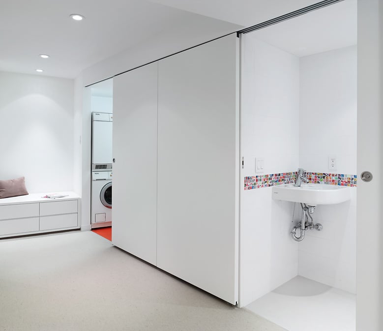 Lacquered wood doors conceal laundry utilities and a powder room in the basement.