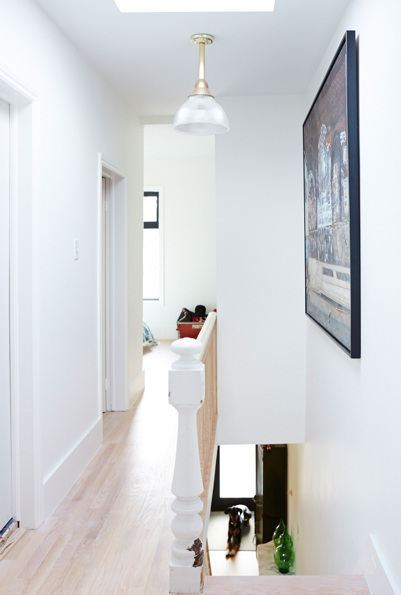 Stairs coming up to a second floor hallway in a narrow home in Toronto