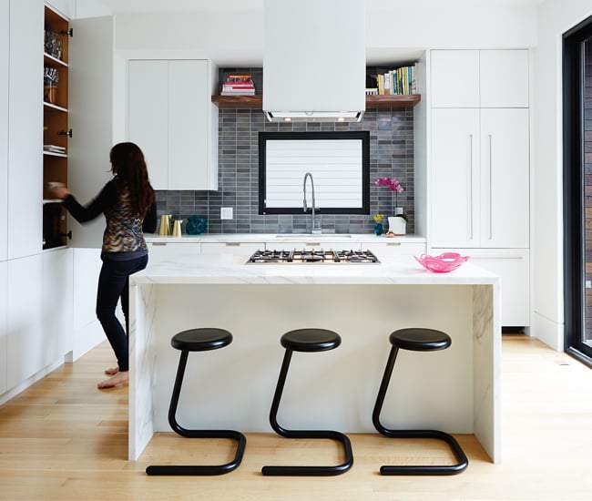 Calacatta marble clads the kitchen’s waterfall island. The backsplash’s hand-made porcelain tiles are from Stone Tile.