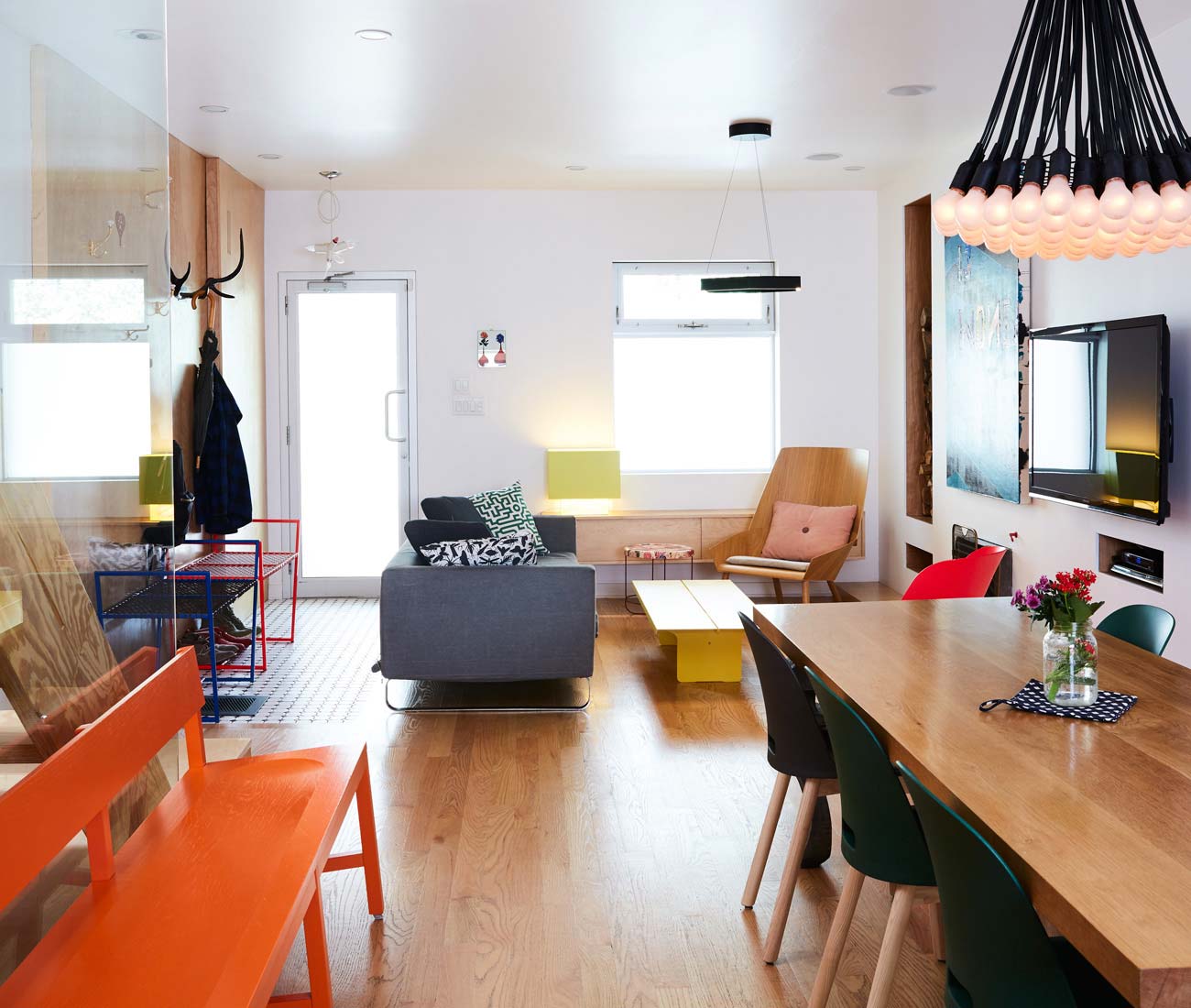 Red-oak flooring warms the white space and grounds the graphic mix of art and furniture at the Thrush Holmes High Park home