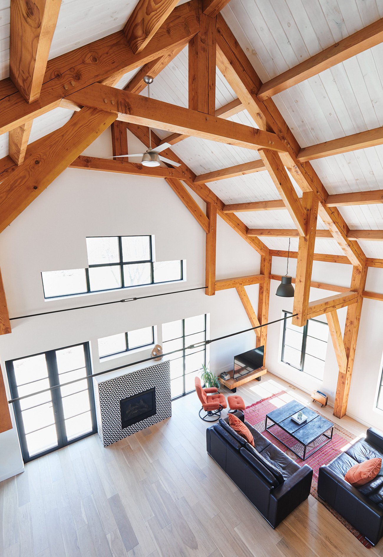 gabled roof with Douglas fir wood beams reaches a nine-metre-tall vaulted ceiling in this timber frame home - Caledon Build