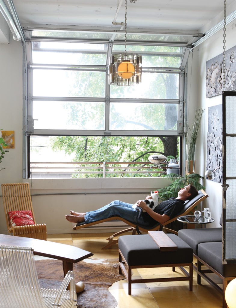 Young man in a living room relaxing on a lounge chair 