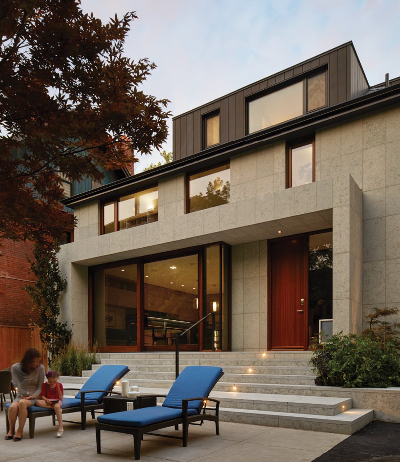 backyard patio of a modern home with people seating on lounge chairs