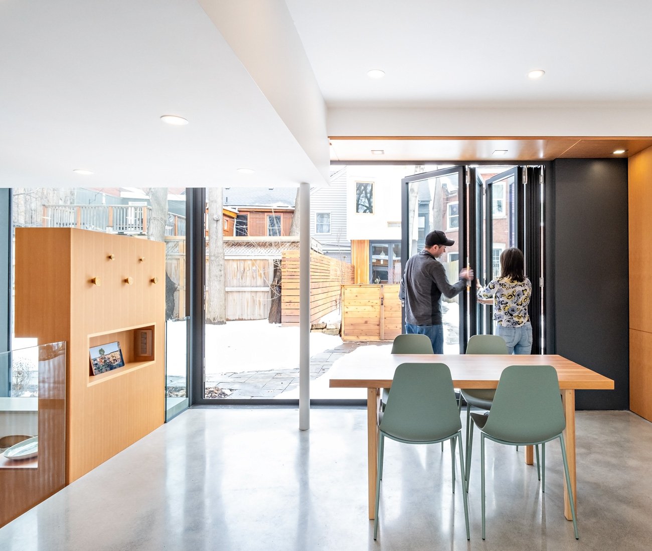 LGA Architects Laneway House Harbord Village Designlines Magazine Deep Douglas fir surround in the living room frames the bi-fold front entrance door by Bigfoot. ZZ Contracting