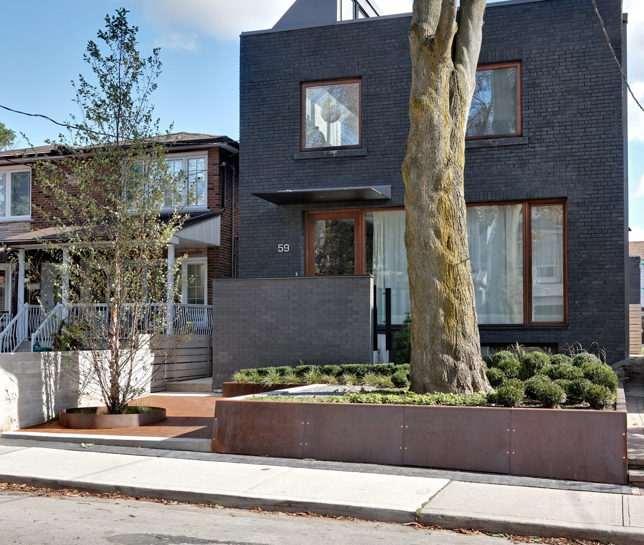 Graphite-grey brick home with modern landscape design by Plant Architects