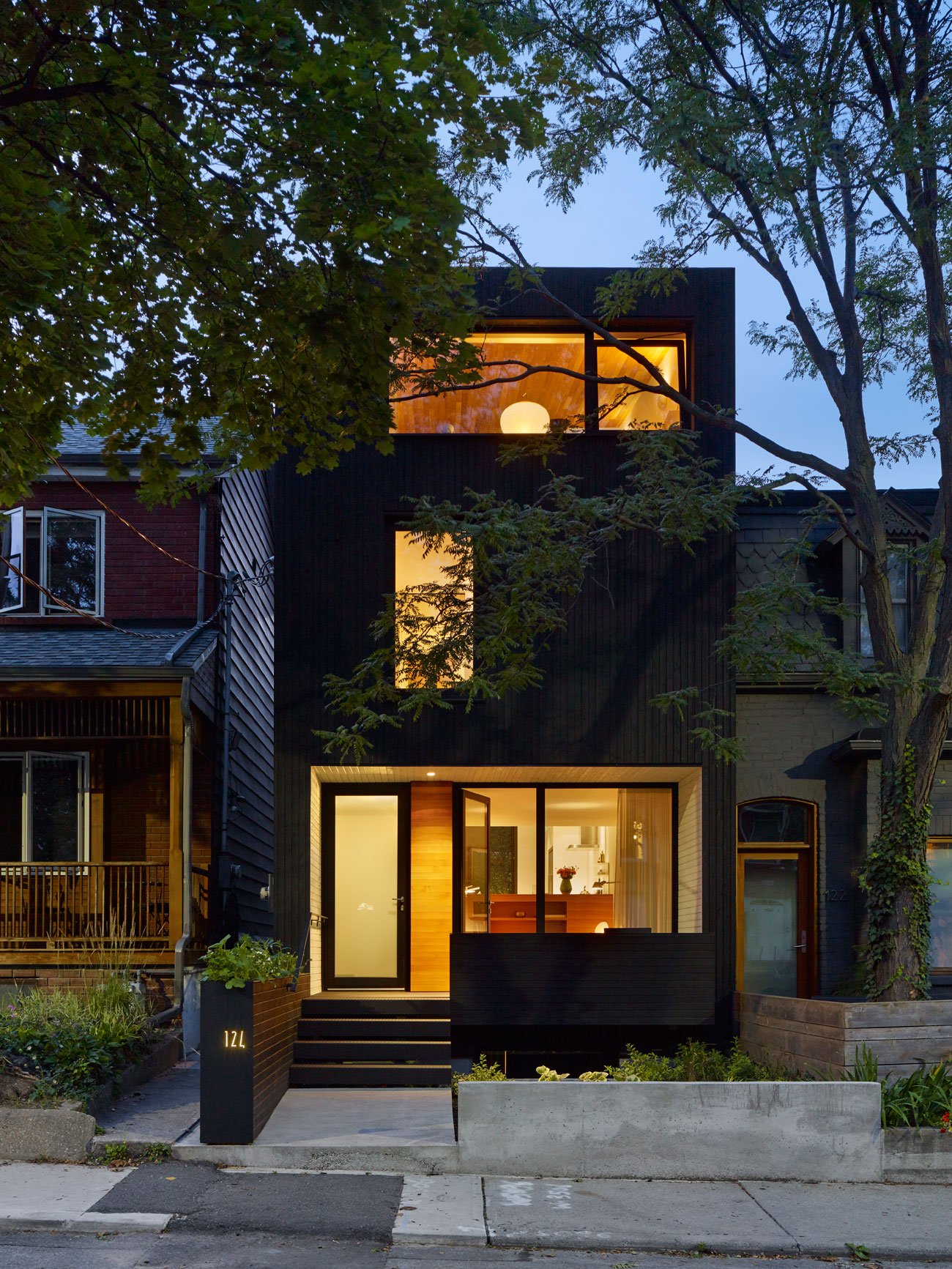 Black wood siding covers the exterior of the modern urban home - Great Lake Studio  design by Great Lake Studio