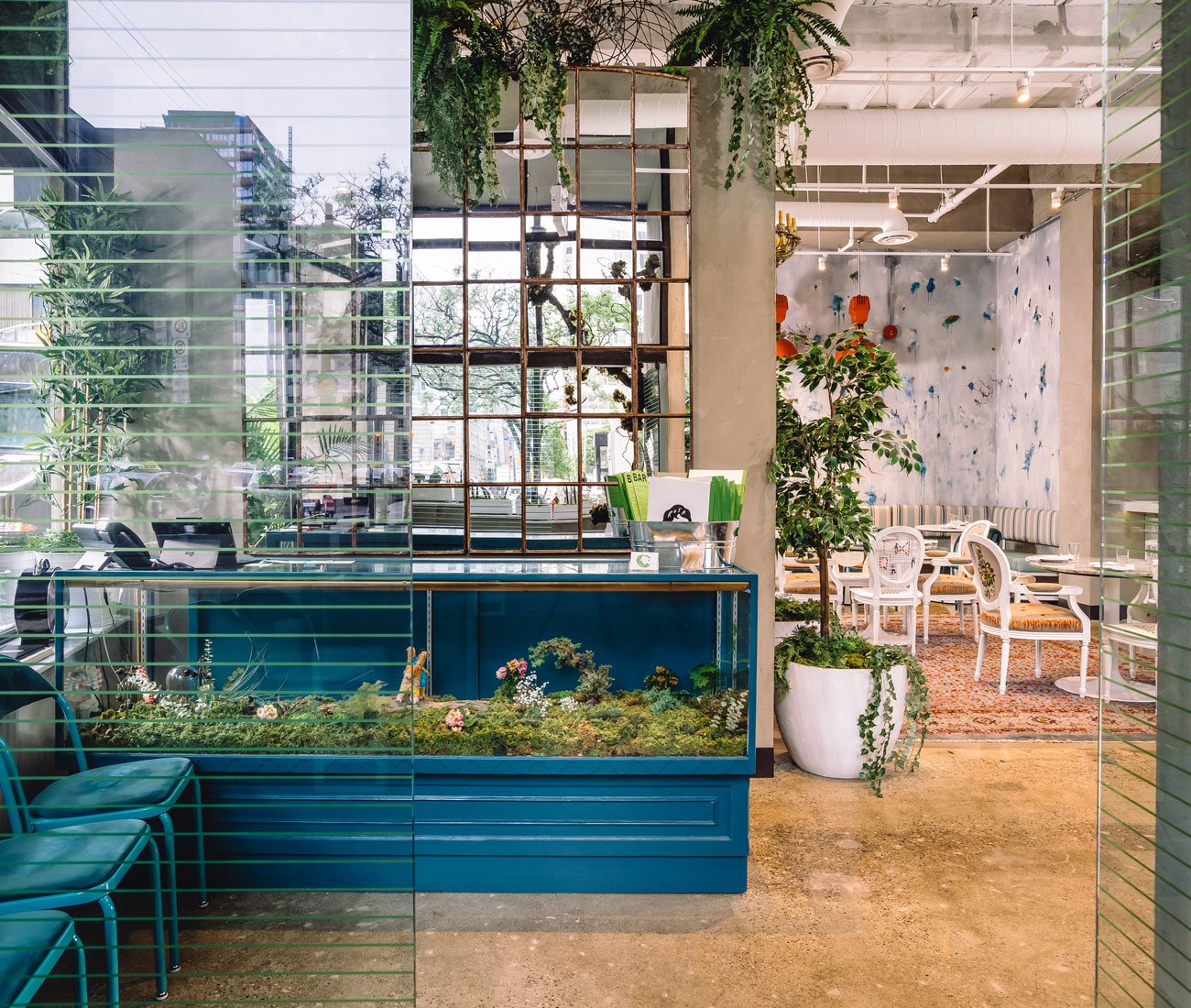 Industrial piping and a mixture of real and artificial greenery at a eatery in Toronto