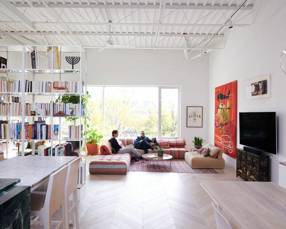2 people having a conversation in a living room of an industrial loft