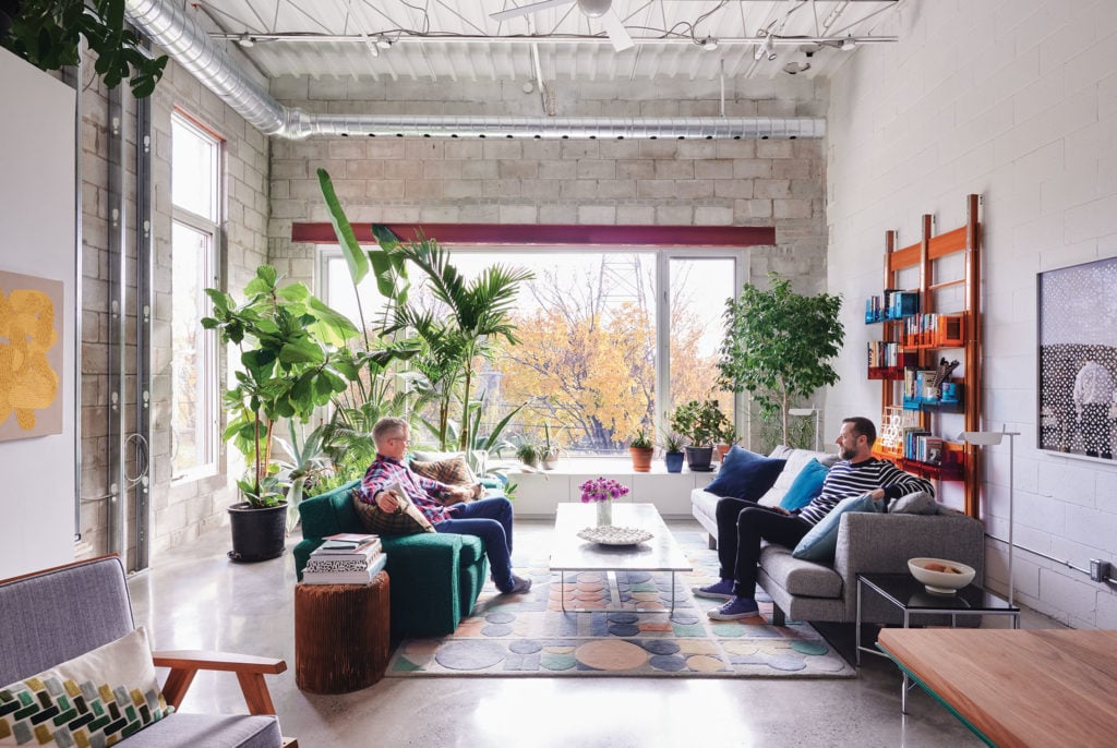 People having a conversation while sitting on sofas in a hard loft living room