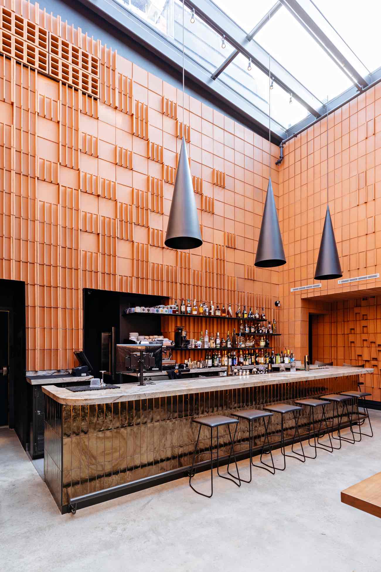 cocktail bar overlooking the main dining space, visible are the terracotta bricks