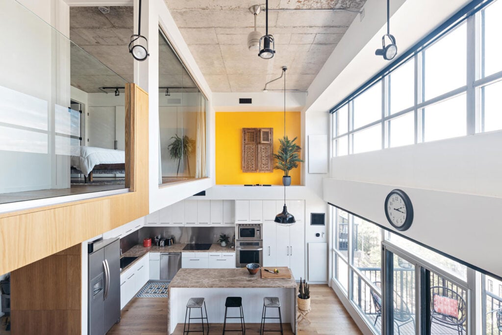 Interior view of a converted hard loft with a kitchen on the main floor and bedrooms on top