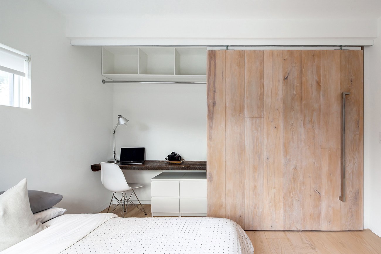 full-height barn door matching the flooring reveals small workspace