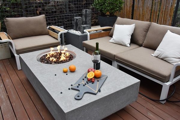 Metropolis outdoor fire pit in a home backyard patio with couches around.