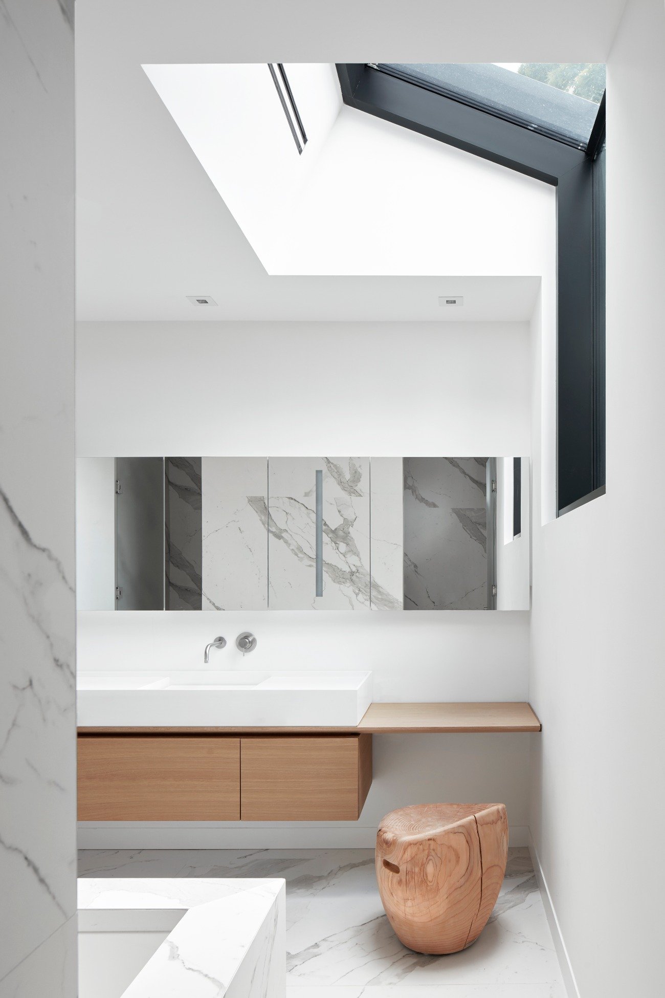 modern bathroom renovations - Custom three-meter vanity, marble-look porcelain slabs, and a skylight with a sky view.