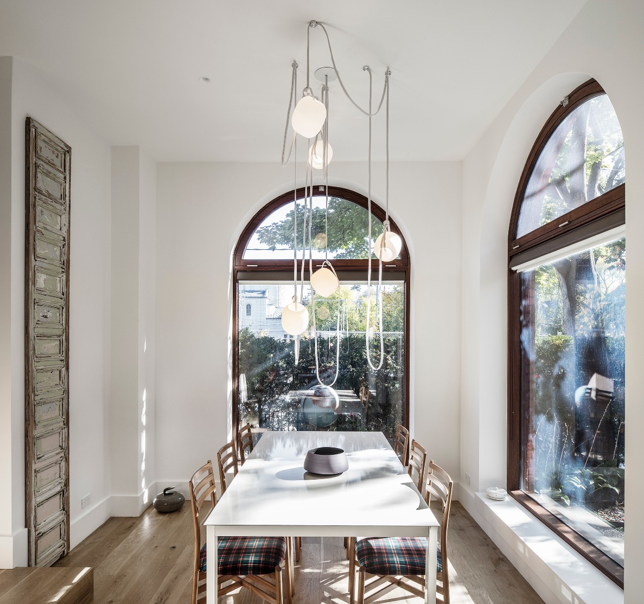 Millwork home, dining table dominated by Rich Brilliant Wiling’s Vitis pendant