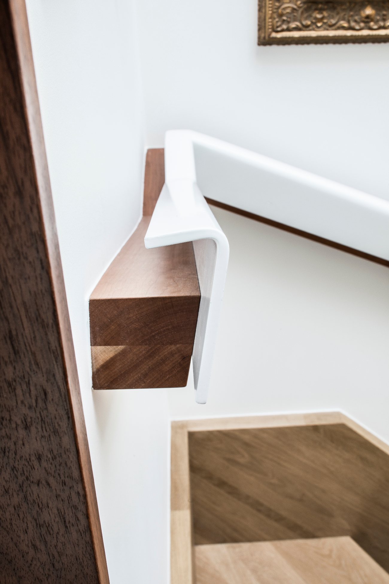 he custom railing is made up of hardwood capped by white powder-coated steel, and features concealed LEDs and regular intervals.