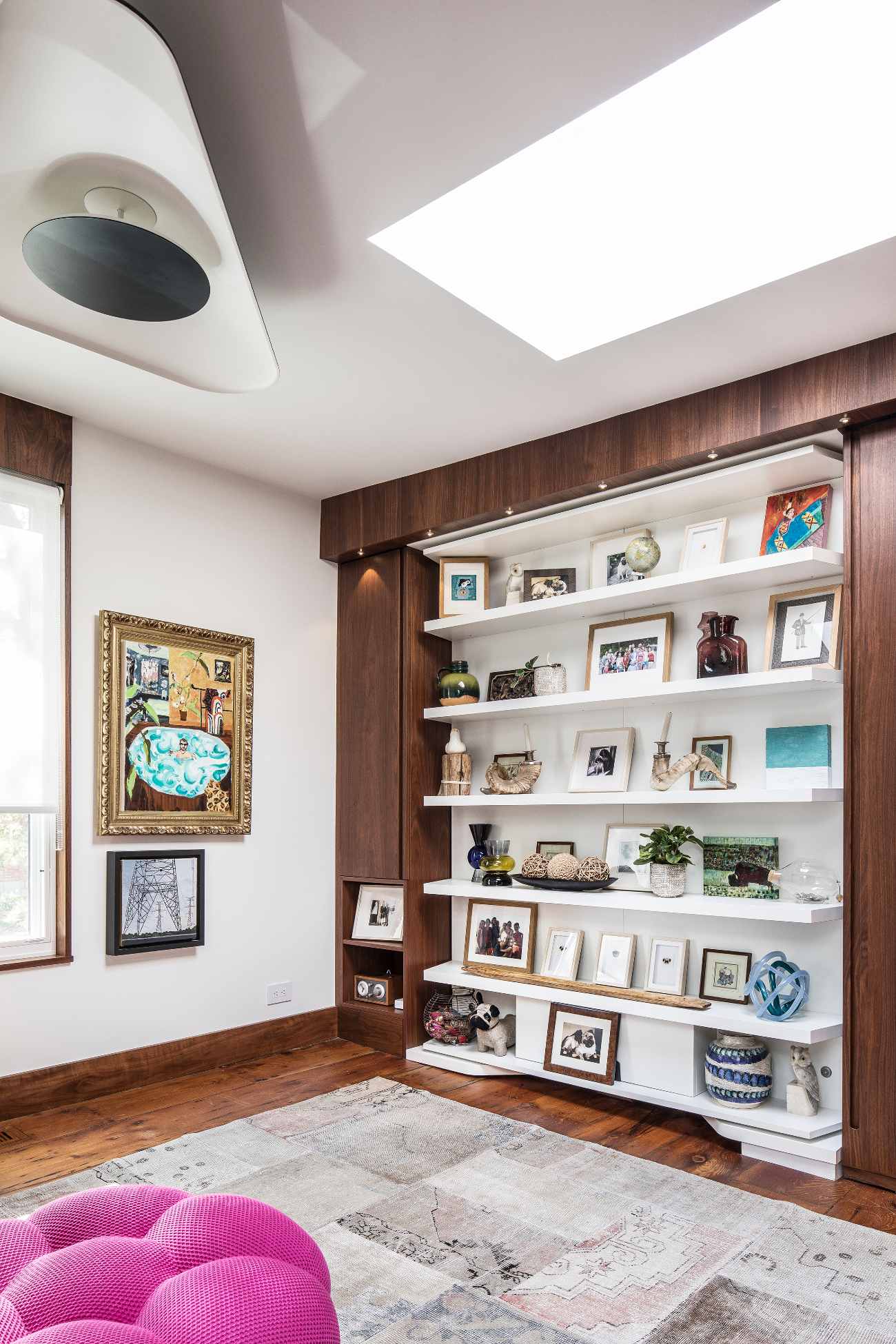 Murphy bed is neatly concealed in the walnut millwork behind the bookshelf