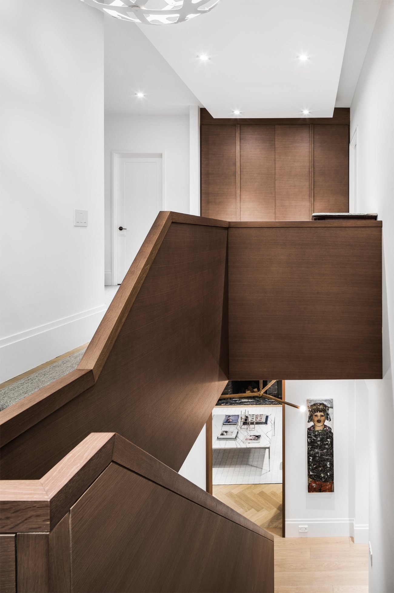 Sculptural dark oak central staircase connecting the main floor to the upper levels in a renovated Georgian home.