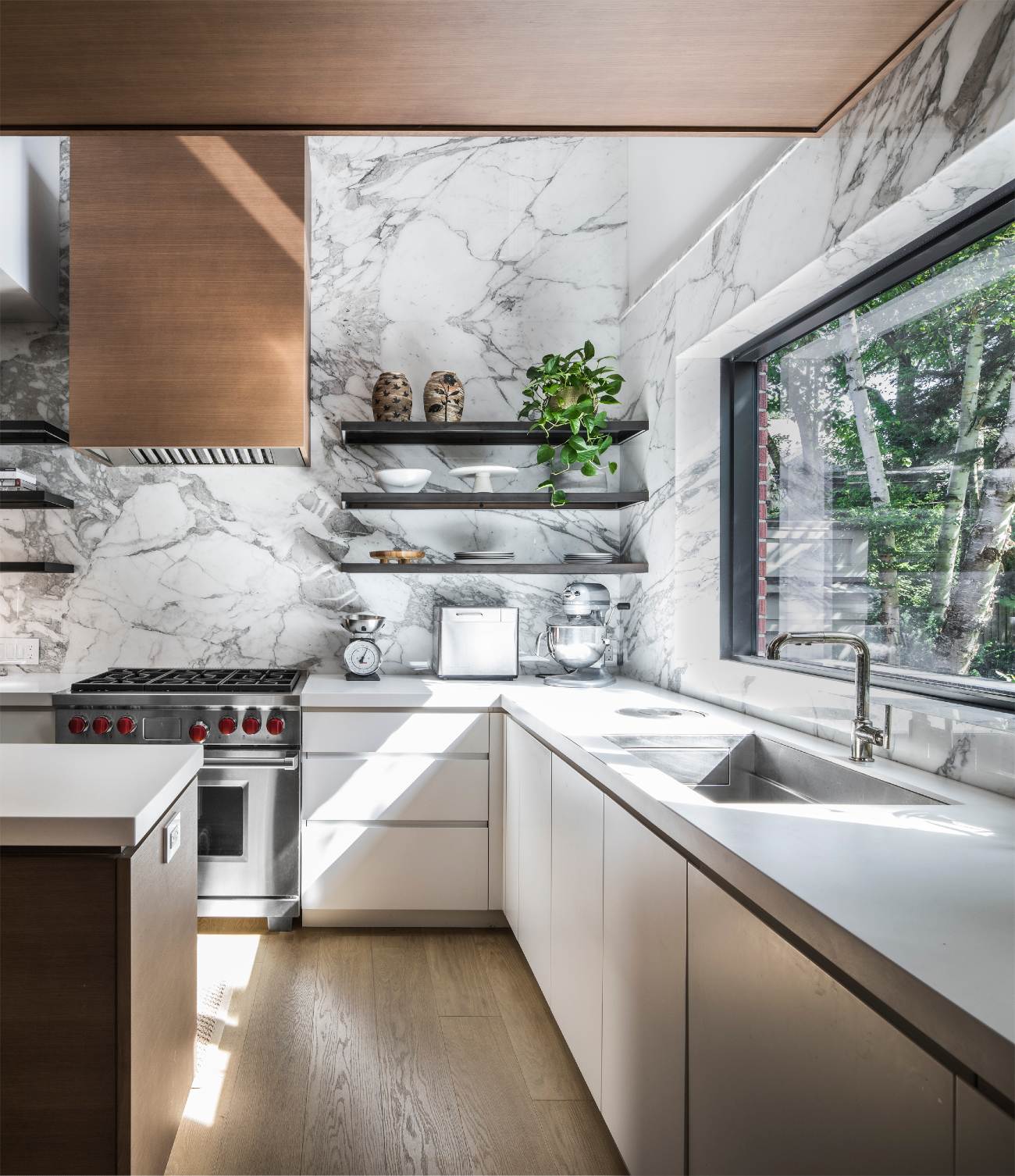 Bright kitchen featuring Calacatta Vagli marble accents and Glacier White Corian countertops. Georgian Reno