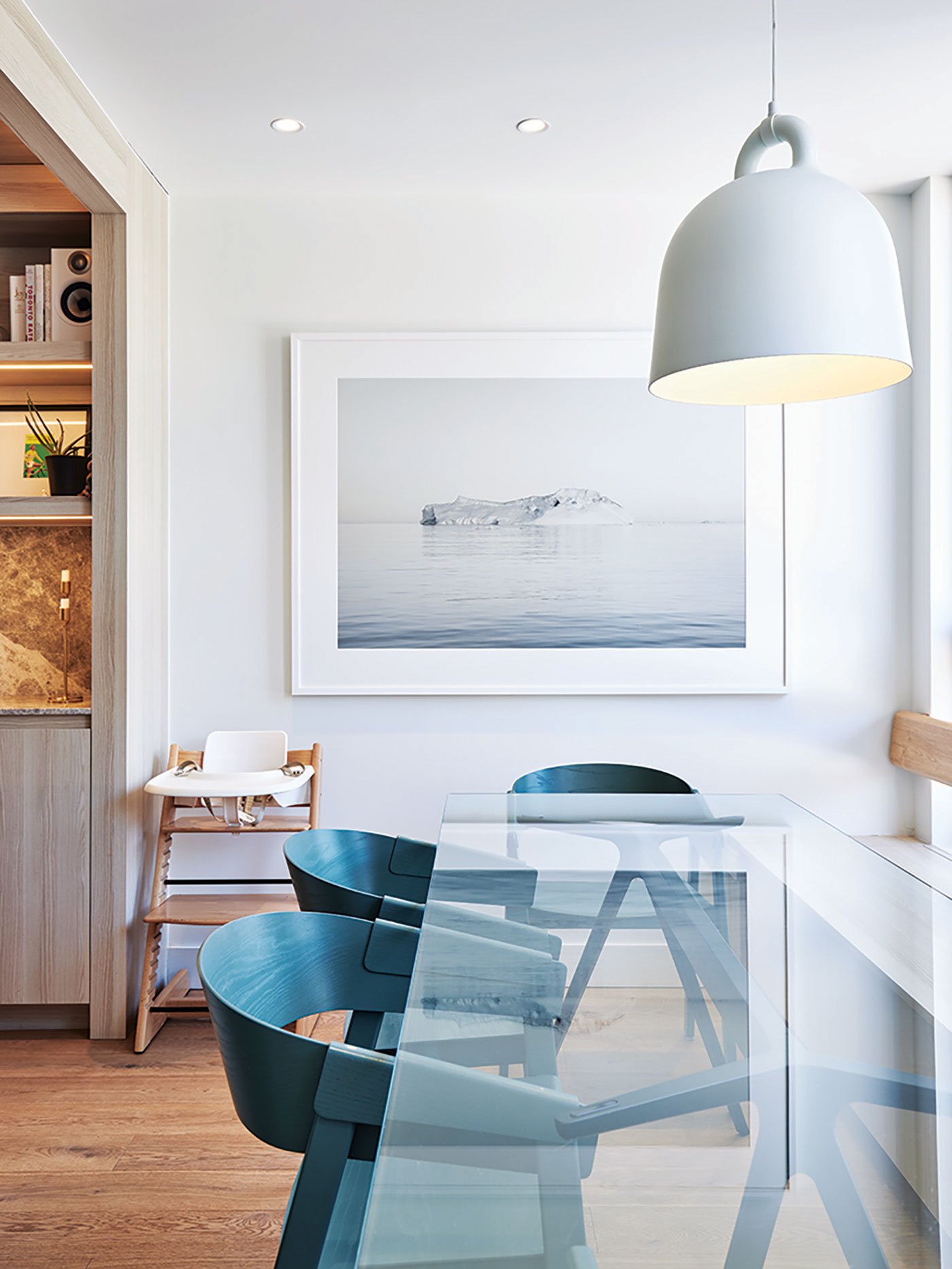 Dining area, a Bell pendant by Normann Copenhagen hangs above a glass-topped table bordered by Muuto armchairs. Artwork by Simon Harsent - Reflect Architecture - Narrow House - Wychwood Barns Toronto