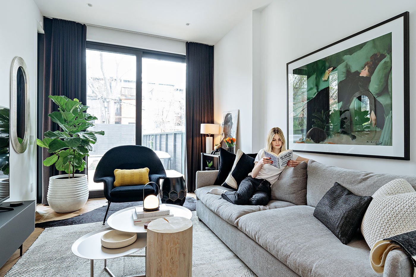 Livingroom with couch and a young woman reading a book - Victorian reno Annex